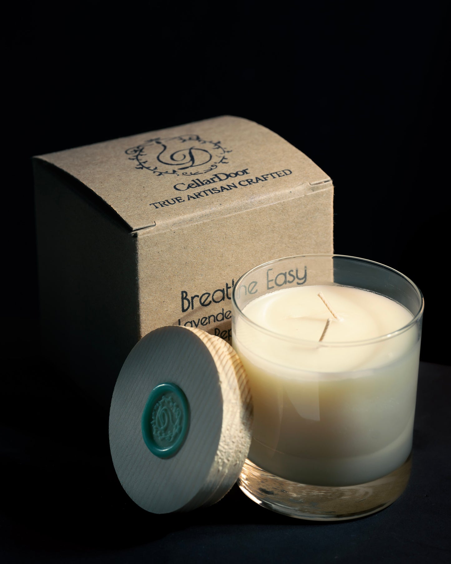 breathe easy candle with the lid off next to the box it is sold in