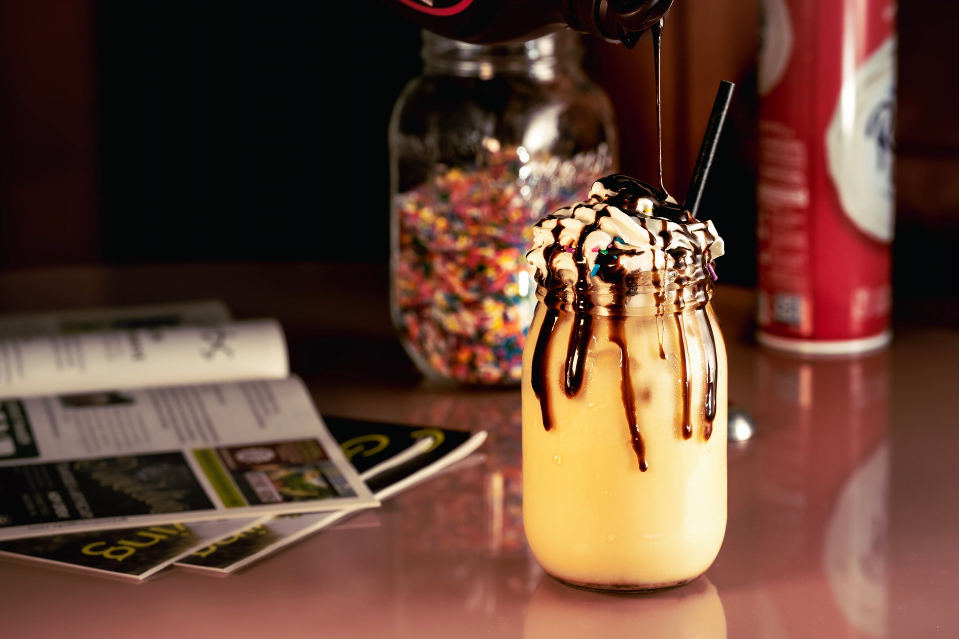 banana split latte with chocolate sauce being poured on top